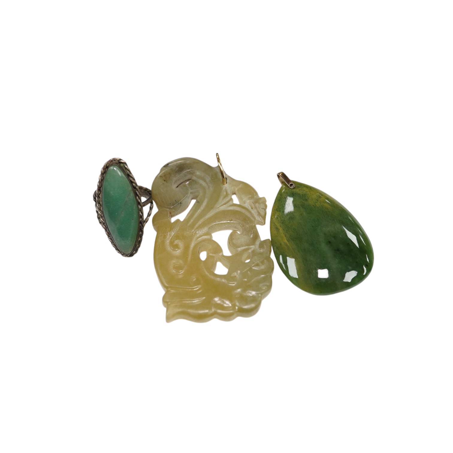 Two jade pendants including a carved example and a jade marquise ring, largest 6.5cm wide. Condition - fair to good